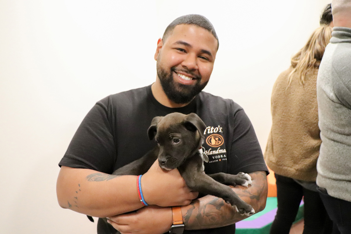 Tito's Volunteer holding puppy