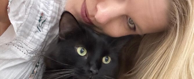 a woman taking a selfie with a cat