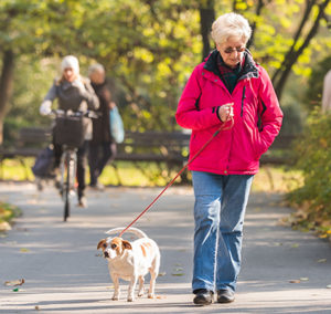 a woman walking a dog on a leash