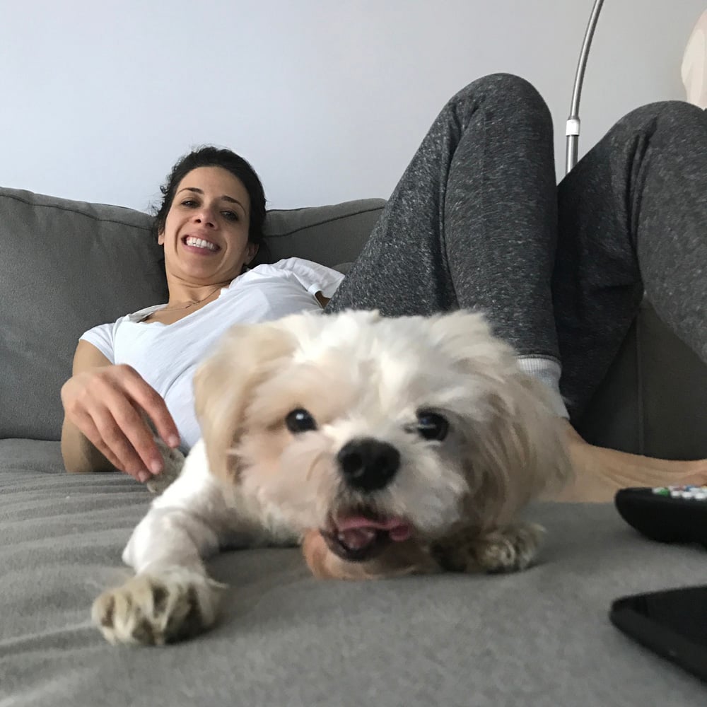 a woman lying on a couch with a dog