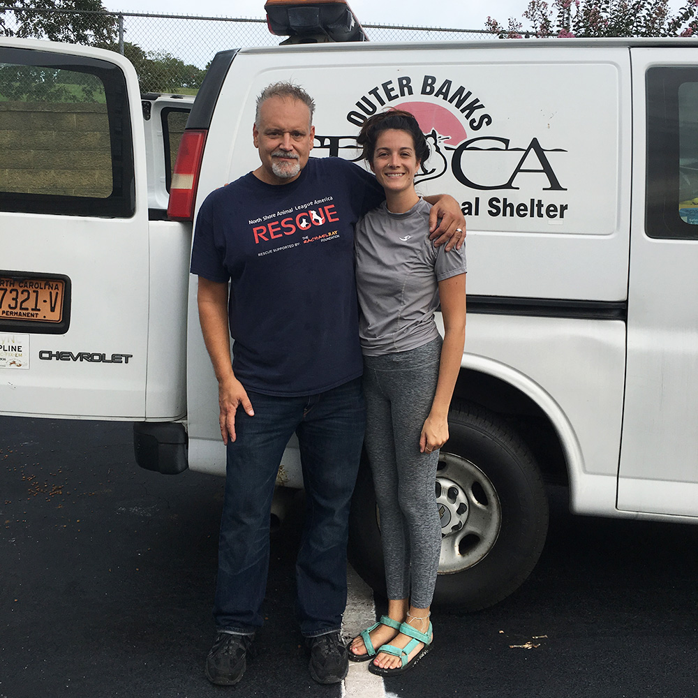 a man and woman standing next to a white van