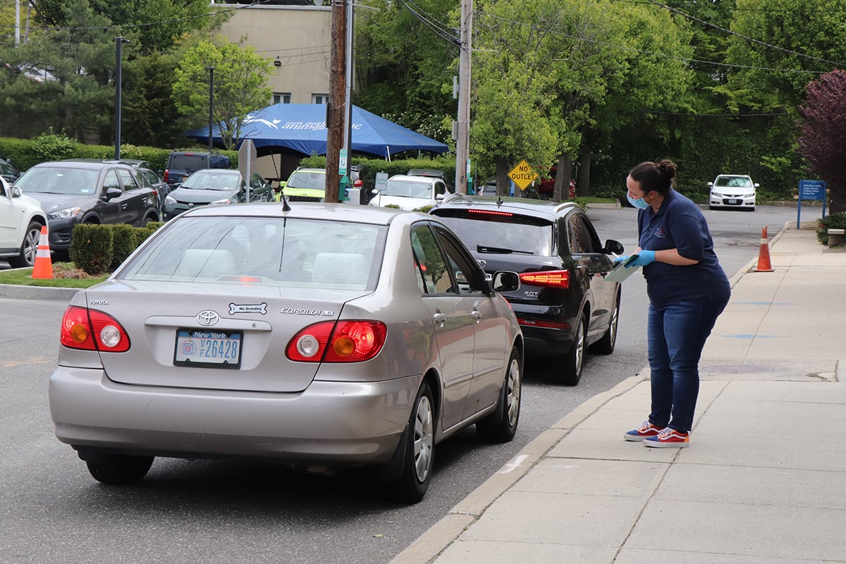 a woman standing on a sidewalk next to a car