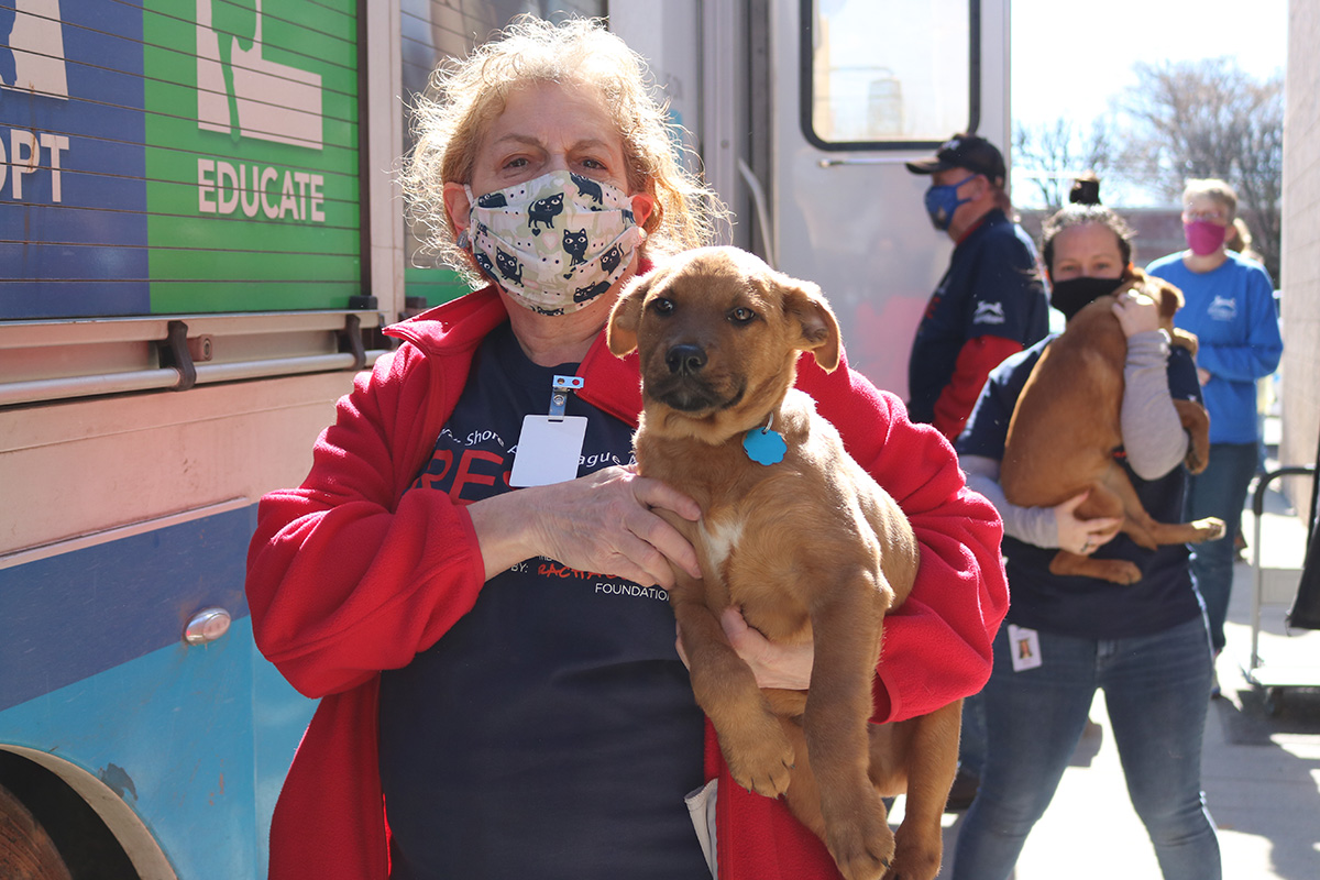 a woman wearing a mask holding a dog