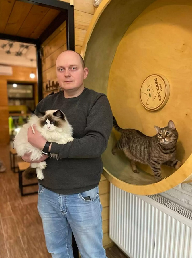 beth-blog-march2022-ukranian-cat-cafe-photo-thedodo.com a man holding a cat