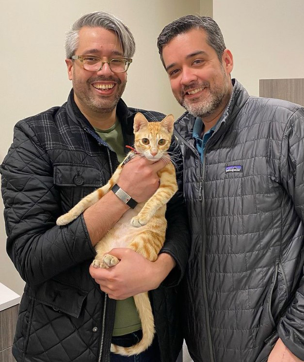 beth-blog-april2022-minnie-adopter two men holding a cat