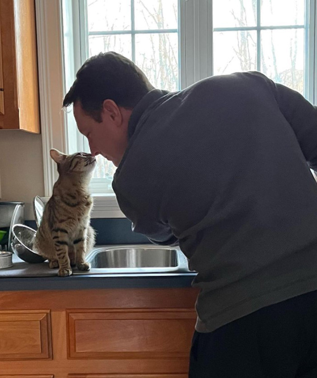 beth-blog-april2022-shrimpy-adopter a man kissing a cat on a counter