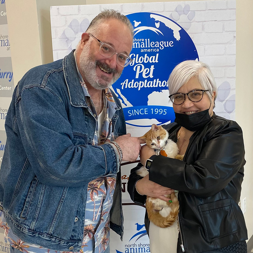 a man and woman holding a cat