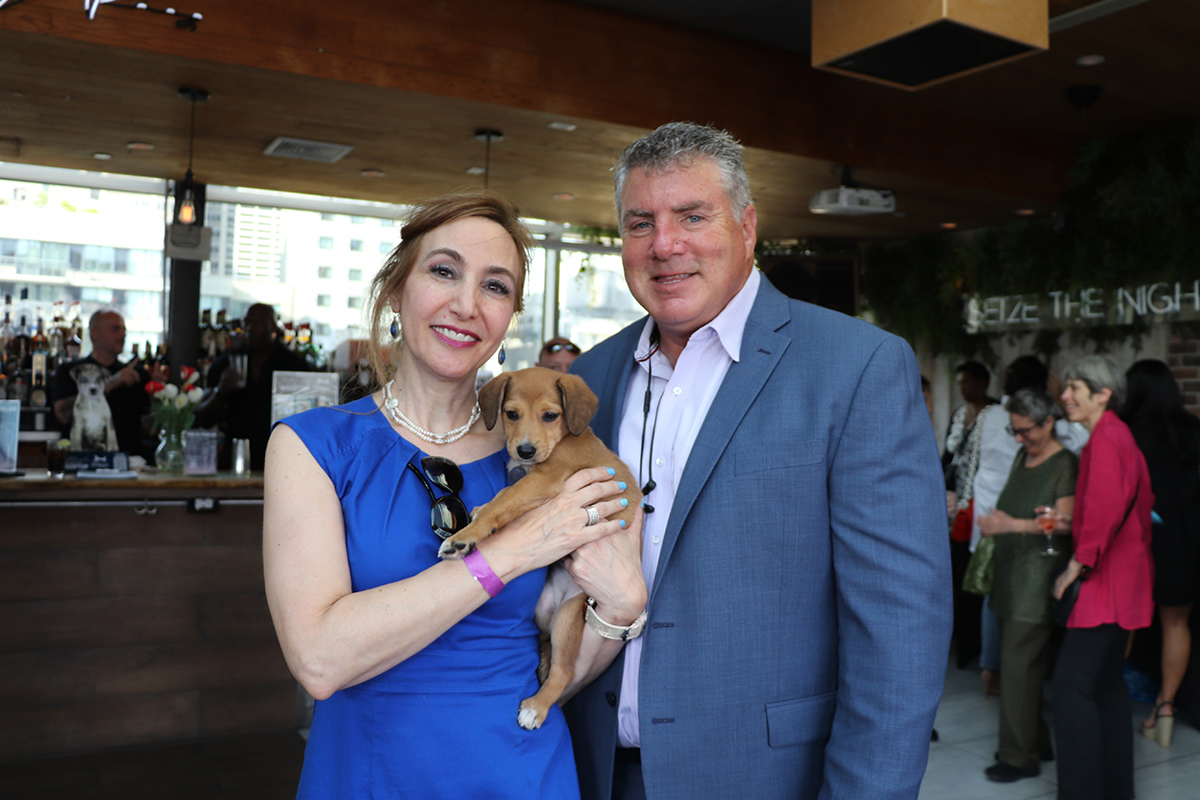 a man and woman holding a dog