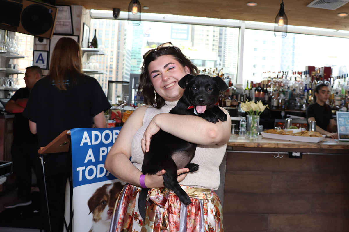 a woman holding a black dog