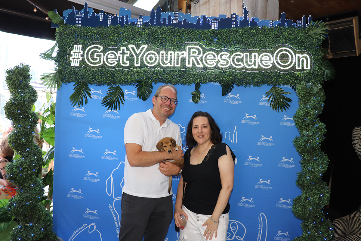 a man and woman posing for a picture with a dog