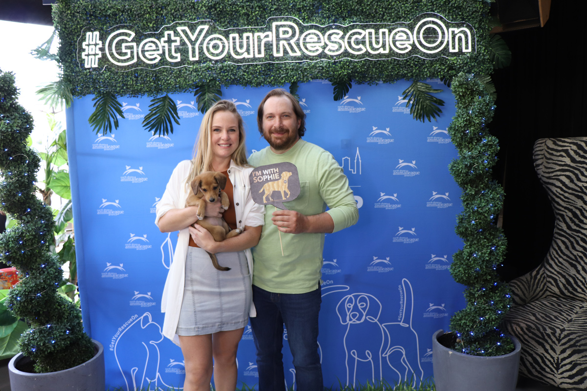 a man and woman posing for a picture with a dog