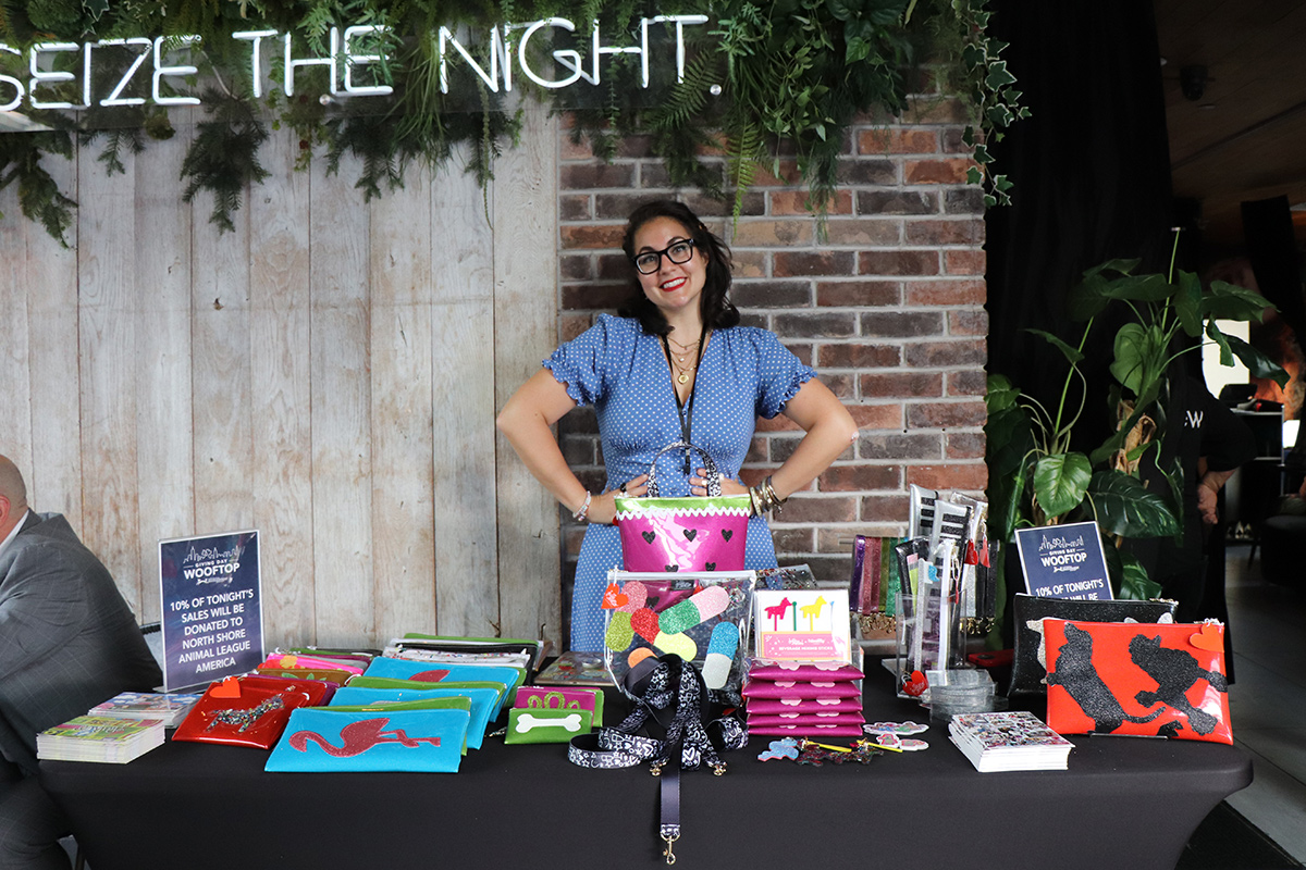 a woman standing in front of a table with a bag and books