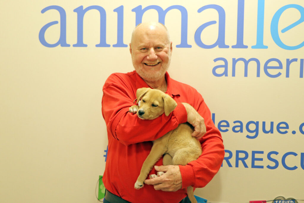 volunteer-month-tom-audette-040323b a man holding a dog