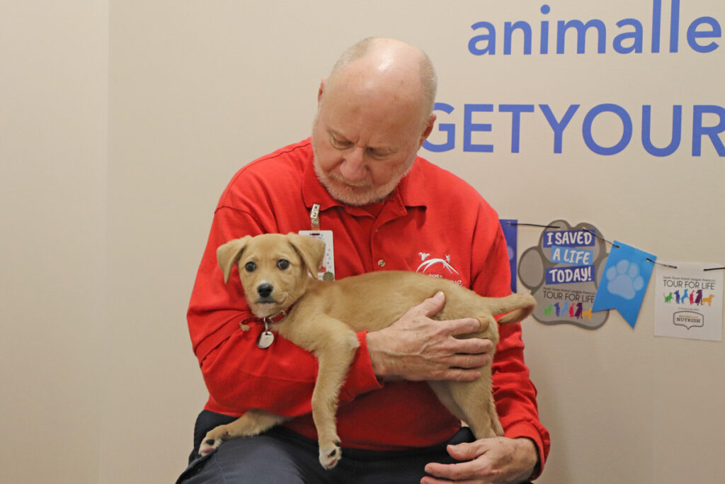 volunteer-month-tom-audette-040323c a man holding a dog