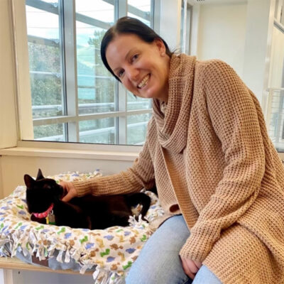 beth-blog-nov-cleo-adopter a woman sitting on a cat bed