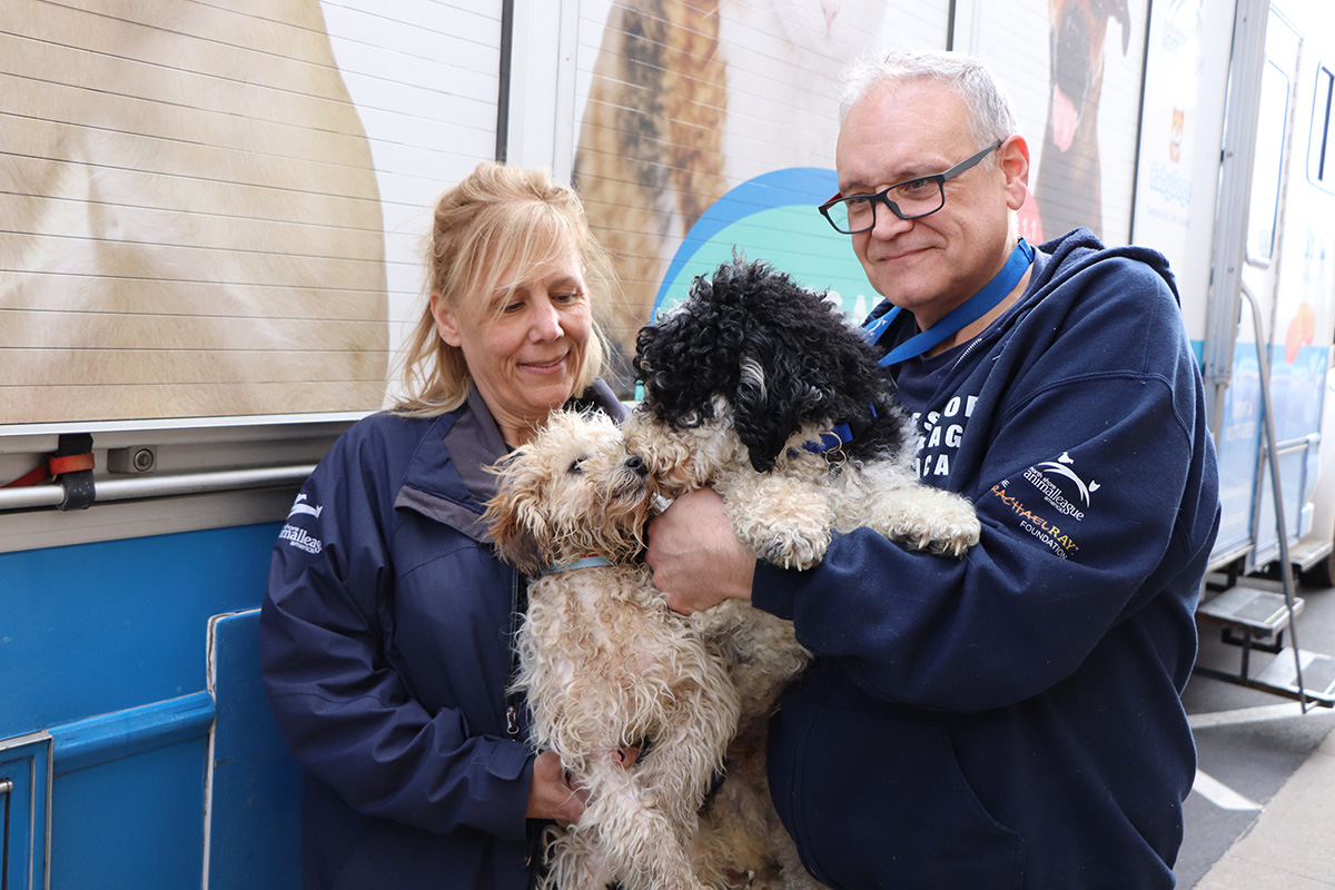 a man and woman holding a dog
